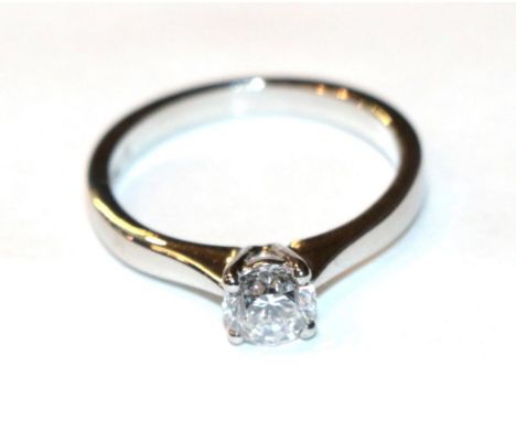 A platinum diamond solitaire ring, a round brilliant cut diamond in a claw setting, to knife edge shoulders, estimated diamon