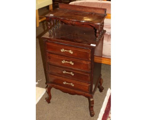 An early 20th century four drawer chest with spindle turned shelf