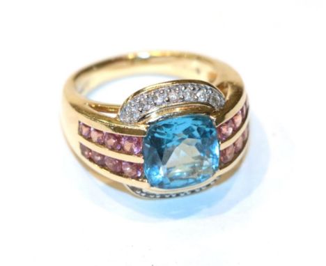 A 14 carat gold blue topaz within a border of pink stones ring, finger size L1/2.  Gross weight 8.6 grams. 