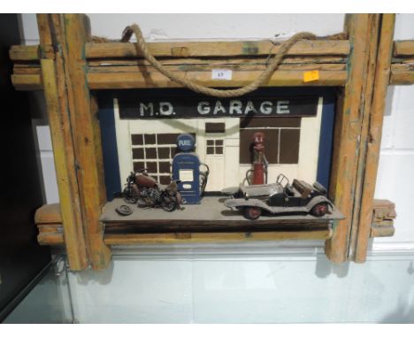 A wooden relief plaque depicting 1950's design garage and Morgan style car
