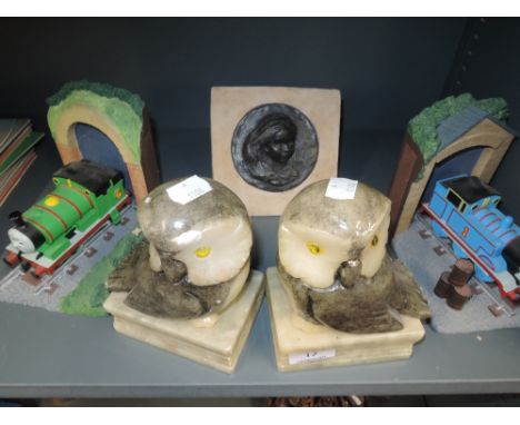 A selection of book ends including Thomas the Tank engine and stone carved Owls