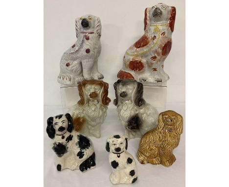 A collection of 7 Staffordshire and Staffordshire style ceramic dogs.  Largest approx. 26cm tall.