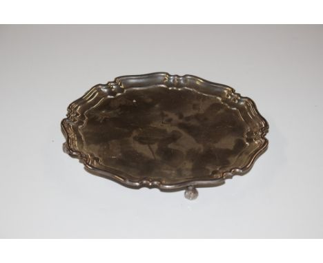 A small silver pie crust bordered card tray raised on scrolled supports, Sheffield 1935, approx. 5ozs