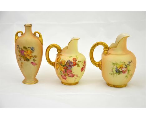 Three pieces of blush Royal Worcester, two flat back ewers and a twin handled vase. Height of ewers 11.5cm. (3)