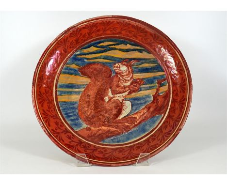 A Maw & Co ruby lustre charger, decorated with a squirrel in a tree with evening sky behind in low relief. Dated 1889. Diamet