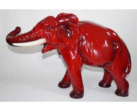 A large Royal Doulton flambe model of an elephant, with trunk outstretched. Impressed and printed marks. Height 28cm.