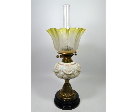 A Victorian oil lamp with a brass column, glass reservoir and a green etched shade. Height 59cm.