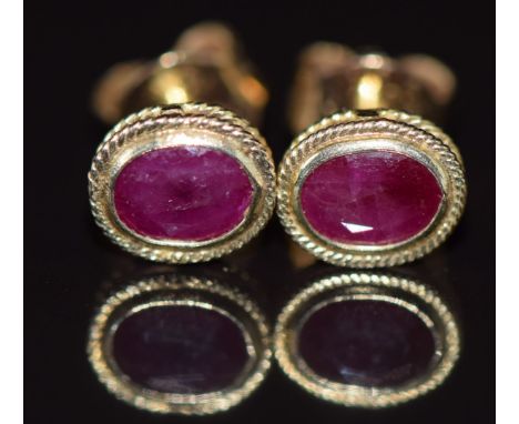 A pair of 9ct gold earrings set with an oval cut ruby to each, 0.8g&nbsp;