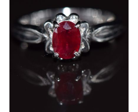 A 9ct white gold ring set with an oval cut ruby, 3.4g, size N