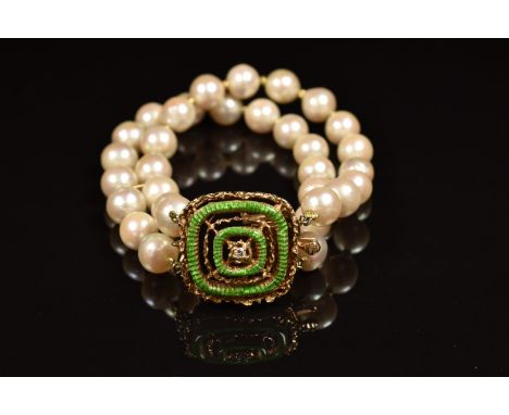 A double strand cultured pearl bracelet, the 14k gold clasp set with a diamond and green enamel
