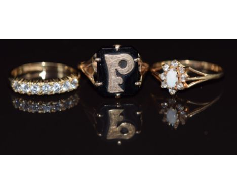 Three 9ct gold rings, one set with an opal and cubic zirconia, one withcubic zirconia and the other onyx and a gold letter P