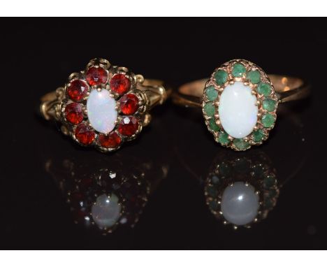 Two 9ct gold rings one set with an opal surrounded by emeralds, the other with an opal surrounded by garnets, 4.4g, size K