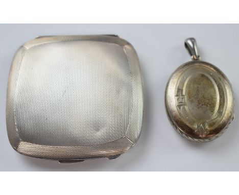 A silver compact with engine turned decoration and Victorian silver locket with engraved bird decoration&nbsp;