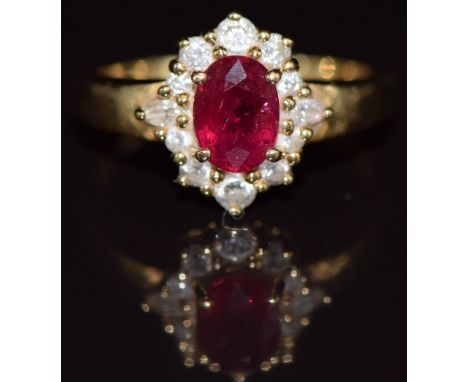An 18ct gold ring set with an oval cut ruby of approximately 1ct surrounded by round and marquise cut diamonds, 4.3g, size L