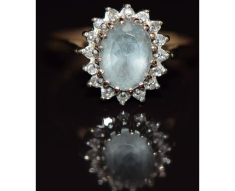 A 9ct gold ring set with an oval cut aquamarine surrounded by diamonds, 2.2g, size K/L