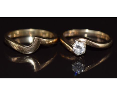 An 18ct gold ring set with a round brilliant cut diamond of approximately 0.2ct,&nbsp;with an 18ct gold wedding band / ring m