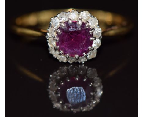 An 18ct gold ring set with a ruby of approximately 1ct surrounded by diamonds, 4.2g, size V