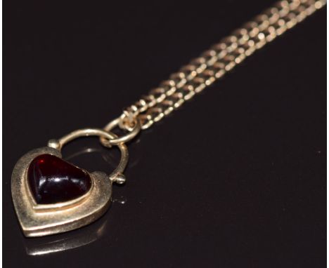 A 9ct gold heart pendant/ padlock set with a heart cut garnet, verso a locket, on 9ct gold chain, 9.6g&nbsp;