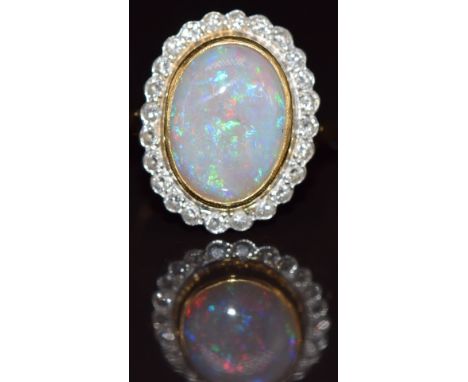 An 18ct gold ring set with an opal cabochon surrounded by diamonds, 6.3g, size M