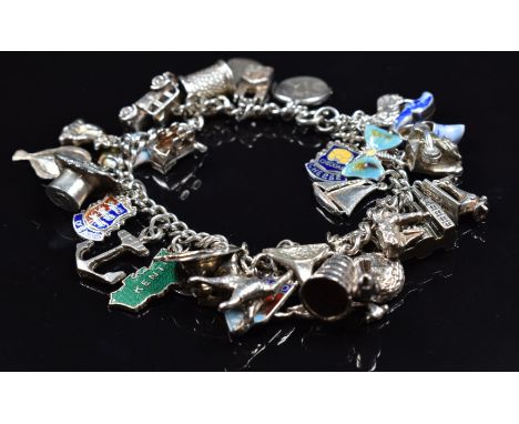 A silver charm bracelet with over 30 charms including enamel butterfly, enamel charms, fish, enamel St Christopher, cat etc