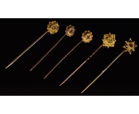 Four 9ct gold stick pins, one set with a diamond, two with a ruby (3.7g), and the other a 15ct gold stick pin set with a diam