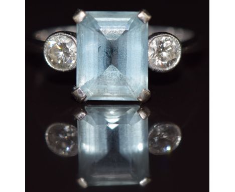 An 18ct white gold ring set with an emerald cut aquamarine of approximately 2.6ct&nbsp;and two diamonds, each approximately 0