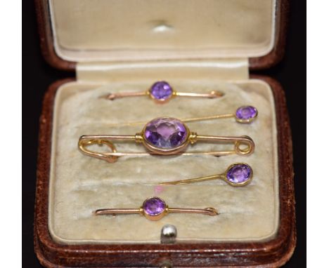 A cased set of three 9ct gold blouse pins/ brooches and two 9ct gold stick pins set with amethysts