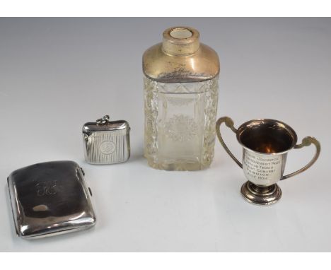 Hallmarked silver items comprising vesta case, cigarette case, miniature twin handled trophy cup and a silver mounted cut gla