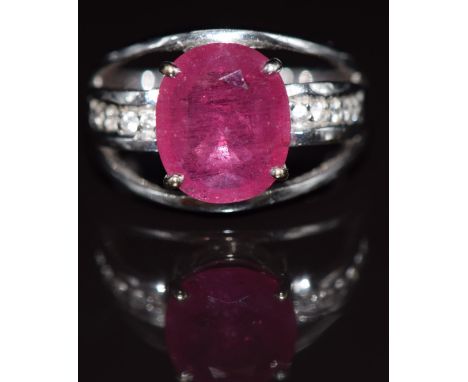 An 18ct white gold ring set with an oval cut ruby and white topaz, 8.3g, size N