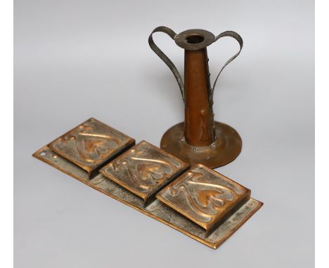 An Arts and Crafts hammered copper candlestick, 18cm tall, and a copper hanging letter rack