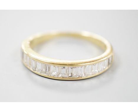 A modern 18ct gold and graduated baguette cut diamond set half eternity ring, size Q, gross 3.4 grams.