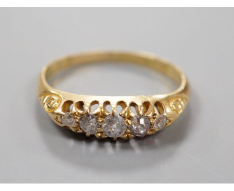 An Edwardian 18ct gold and graduated five stone diamond set half hoop ring, size M, gross weight 2.5 grams.