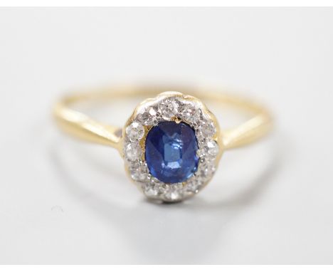 An 18ct, sapphire and diamond set oval cluster ring, size M, gross weight 1.7 grams.