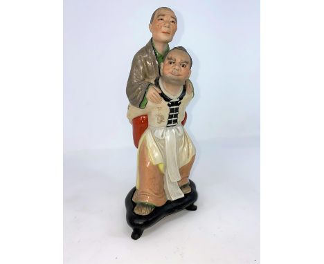 A Chinese ceramic group , son carrying mother on his back (some areas of damage) on wooden stand (a.f.) 23cm(chip to base and