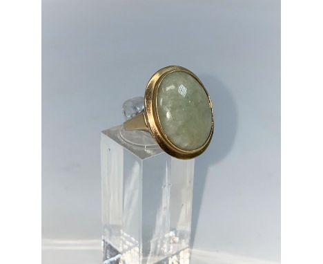 A 9 carat hallmarked gold dress ring set with oval jade coloured stone, size O1/2, 6.3gm 