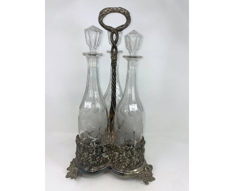 A 19th century 3 bottle decanter stand with extensive vine relief decoration, with 3 vine etched glass decanters 