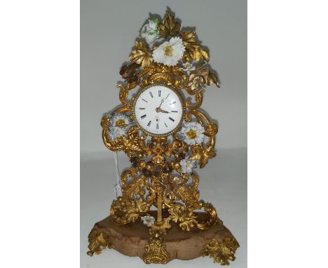 An unusual 18th century Rococo mantel clock formed from pierced and embossed gilt metal foliage with encrusted china flowers,