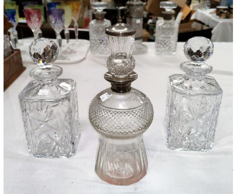 A thistle shaped cut decanter with silver mounted stopper and rim, London 1927; a pair of modern cut crystal decanters 