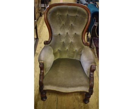 A Victorian walnut button back armchair, on lotus leaf capped front legs