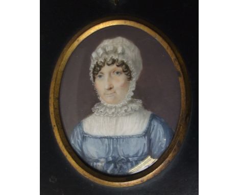 An oval bust portrait miniature, of a lady wearing a mop cap, watercolour, 8 x 6 cm