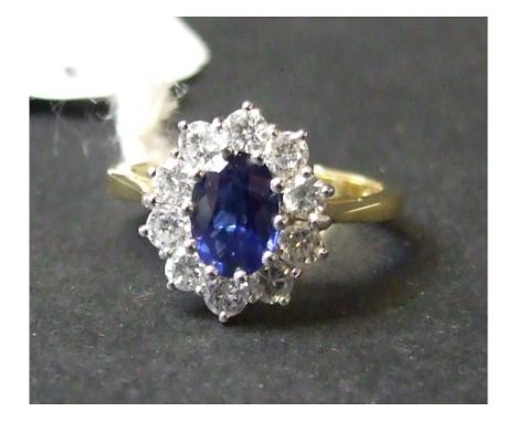 An 18ct gold, oval sapphire and diamond cluster ring, approx. ring size K