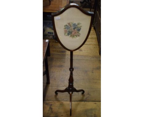A rosewood pole screen, on a tripod base