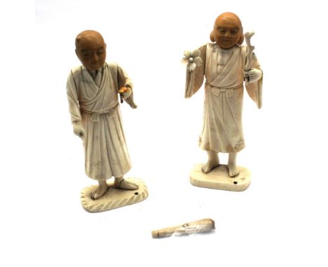 A pair of 19th or 20th century Chinese carved bone figures of Buddhist men, possibly Immortals / Deities, one holding a flowe