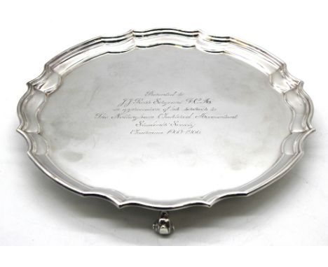 An Elizabeth II silver salver, with scrolled edge and on three scrolled feet, engraved to centre "Presented to F.F. Ross Serg