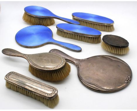 A George V matching silver dressing table set consisting of hand mirror, hand brush and two clothes brushes, all with vibrant