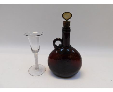 A late 18th/early 19th Century brown glass bluster decanter with neck figure handle, stopper silver brandy label along with a