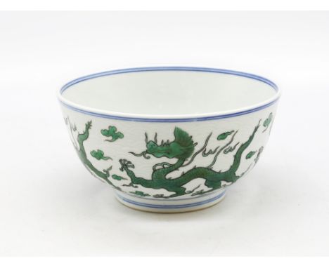 A Chinese porcelain dragon bowl in Kangxi style but 20th century, decorated in green enamels with sky dragons against a conce