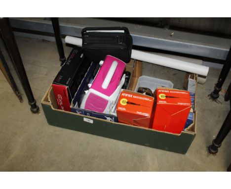 A box containing Leica camera manual, a Leica camera family tree poster, microphones, a singing machine, a Casio digital came