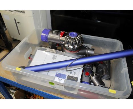 A Dyson V8 vacuum cleaner with various accessories and manual