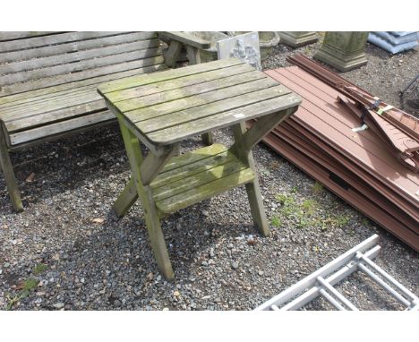 A wooden garden table fitted shelf below